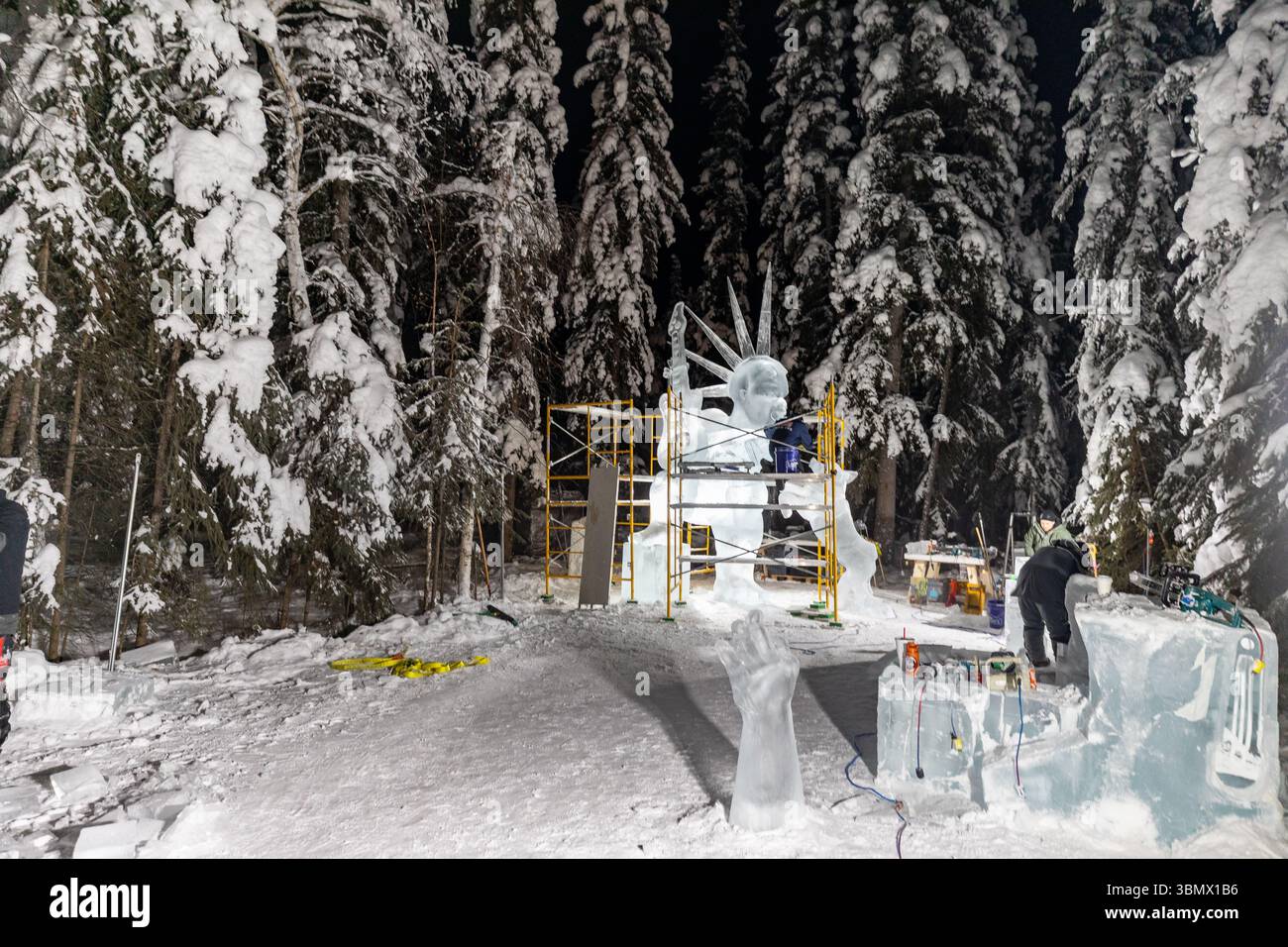 Fairbanks, USA - 21. Februar 2023: Künstler arbeiten nachts an großen Eisskulpturen für die Eiskunstweltmeisterschaften, den Eisskulpturwettbewerb und das Festival Stockfoto