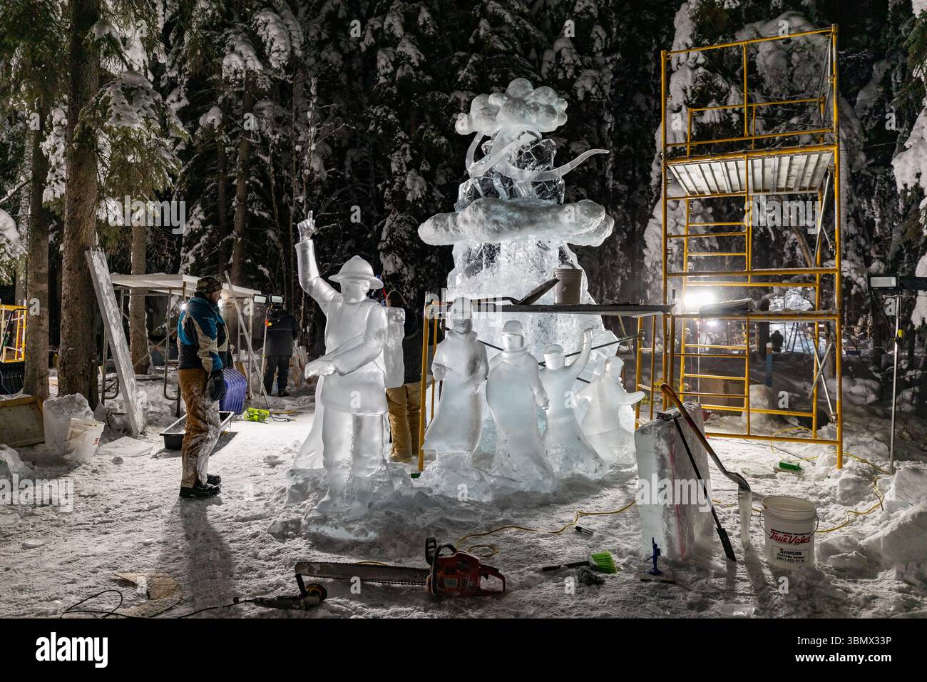 Fairbanks, USA - 21. Februar 2023: Künstler arbeiten nachts an großen Eisskulpturen für die Eiskunstweltmeisterschaften, den Eisskulpturwettbewerb und das Festival Stockfoto
