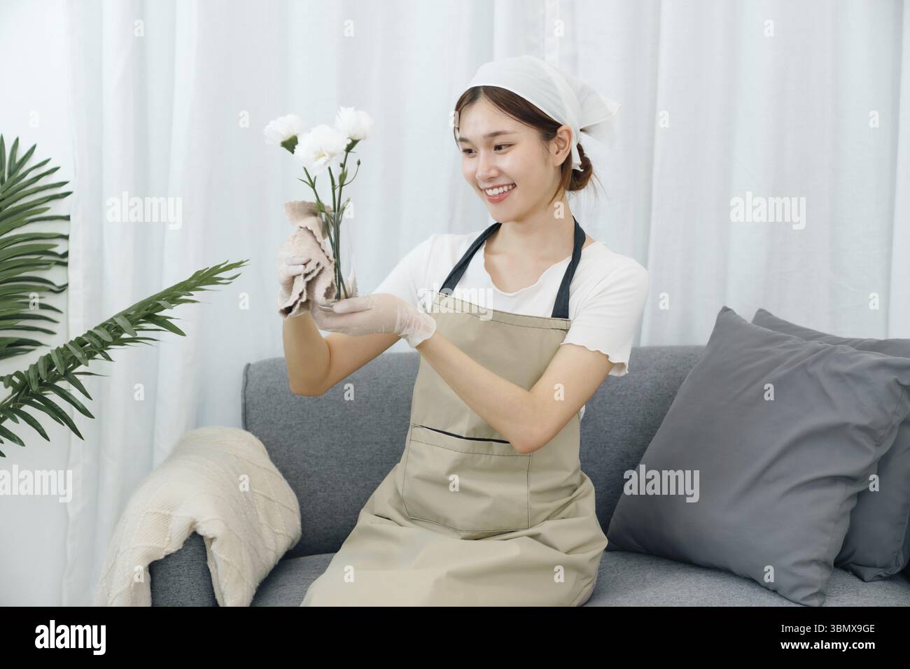 Glückliche asiatische Hausfrau, die sich perfekt auf die Reinigung vorbereitet Stockfoto