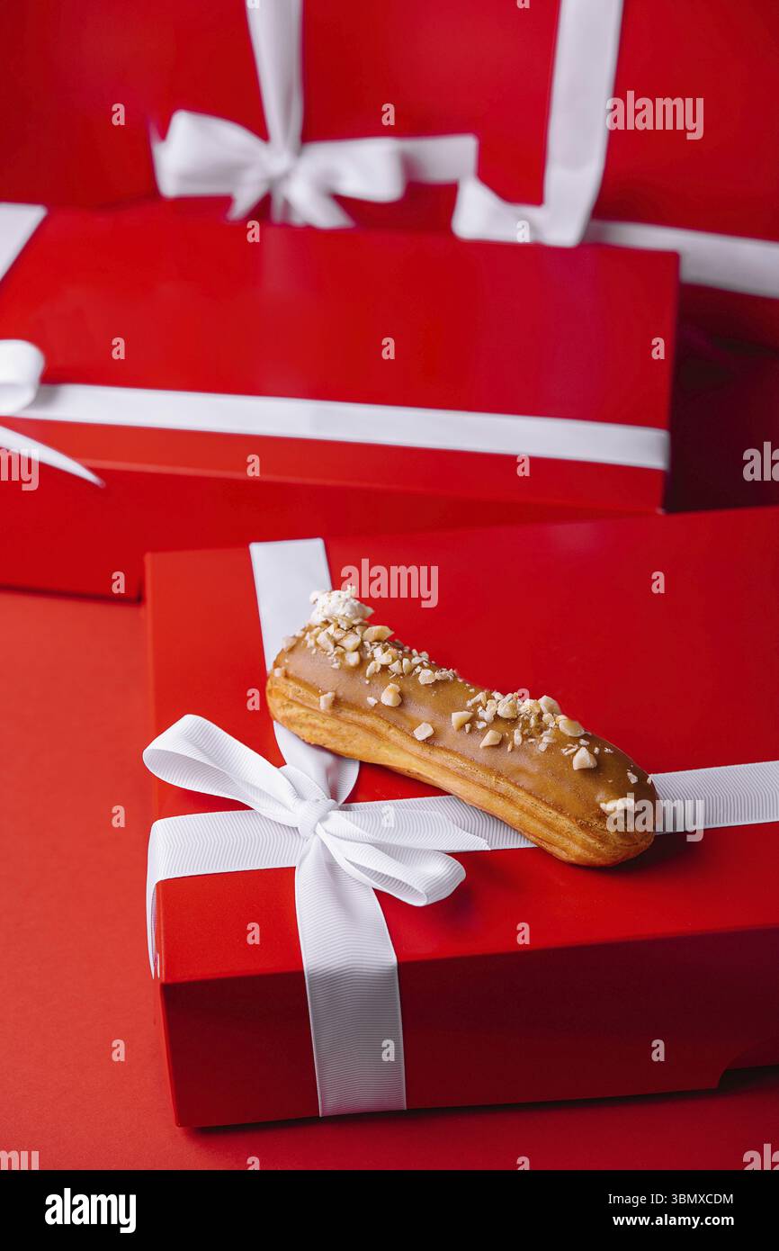 Essen Stillleben, Weihnachtsgeschenke Geschenke mit französischem Eclair Stockfoto