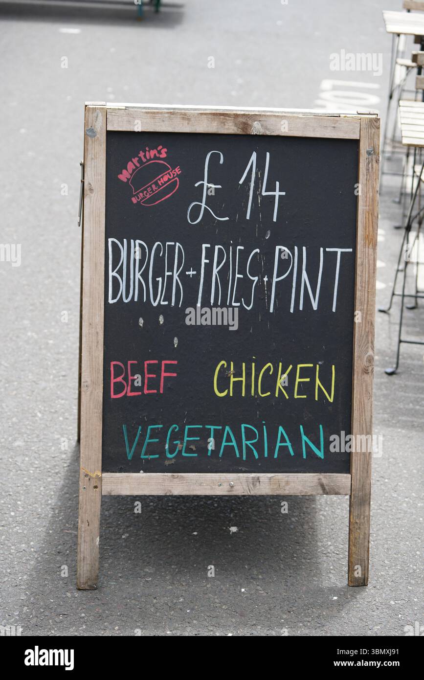 Preistafel Werbung Burger Mahlzeit Optionen und Getränke außerhalb des Cafés. Brighton, England Stockfoto