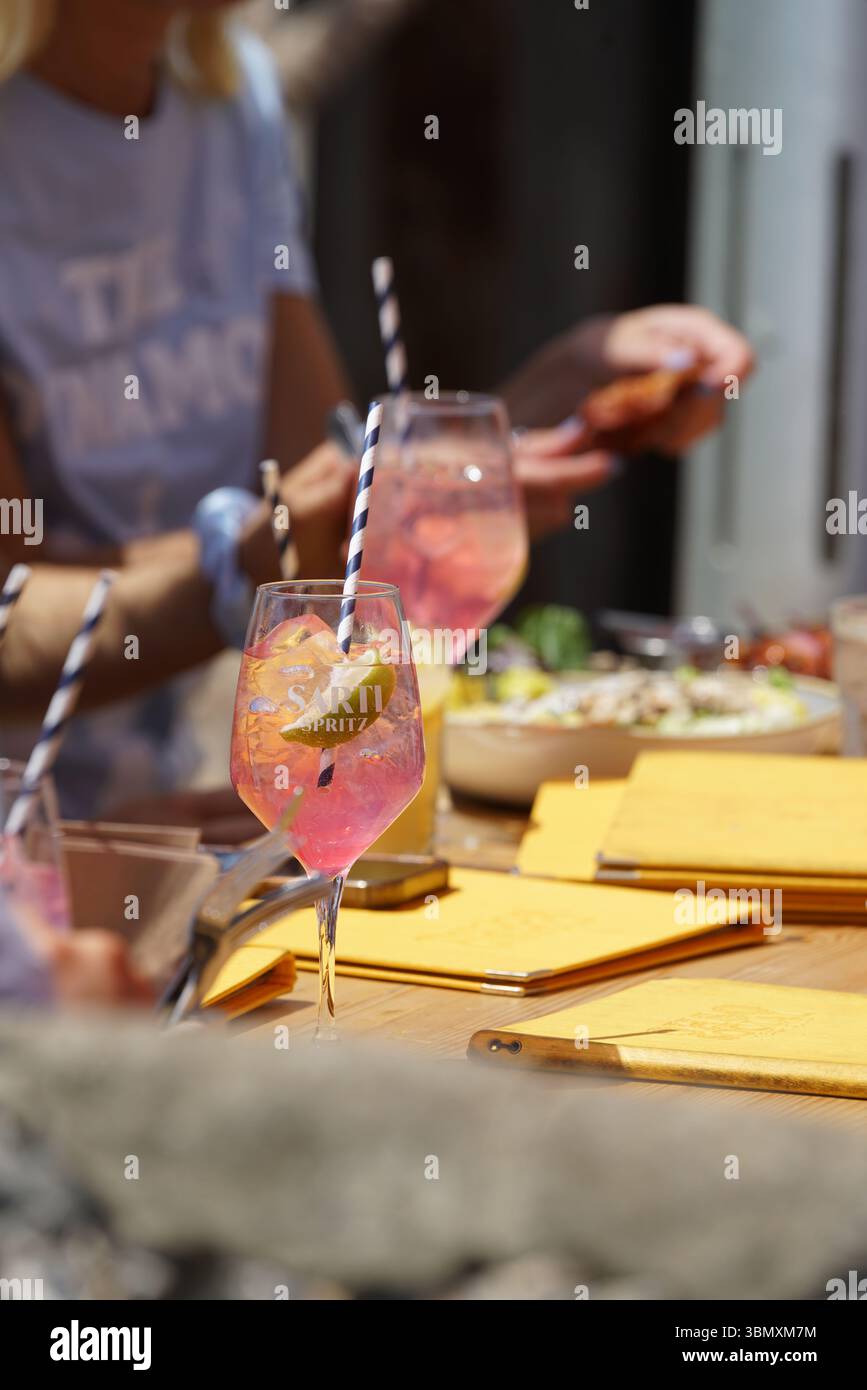 Mittagessen im Freien mit erfrischenden Getränken und lebhafter Atmosphäre. Brighton, England Stockfoto