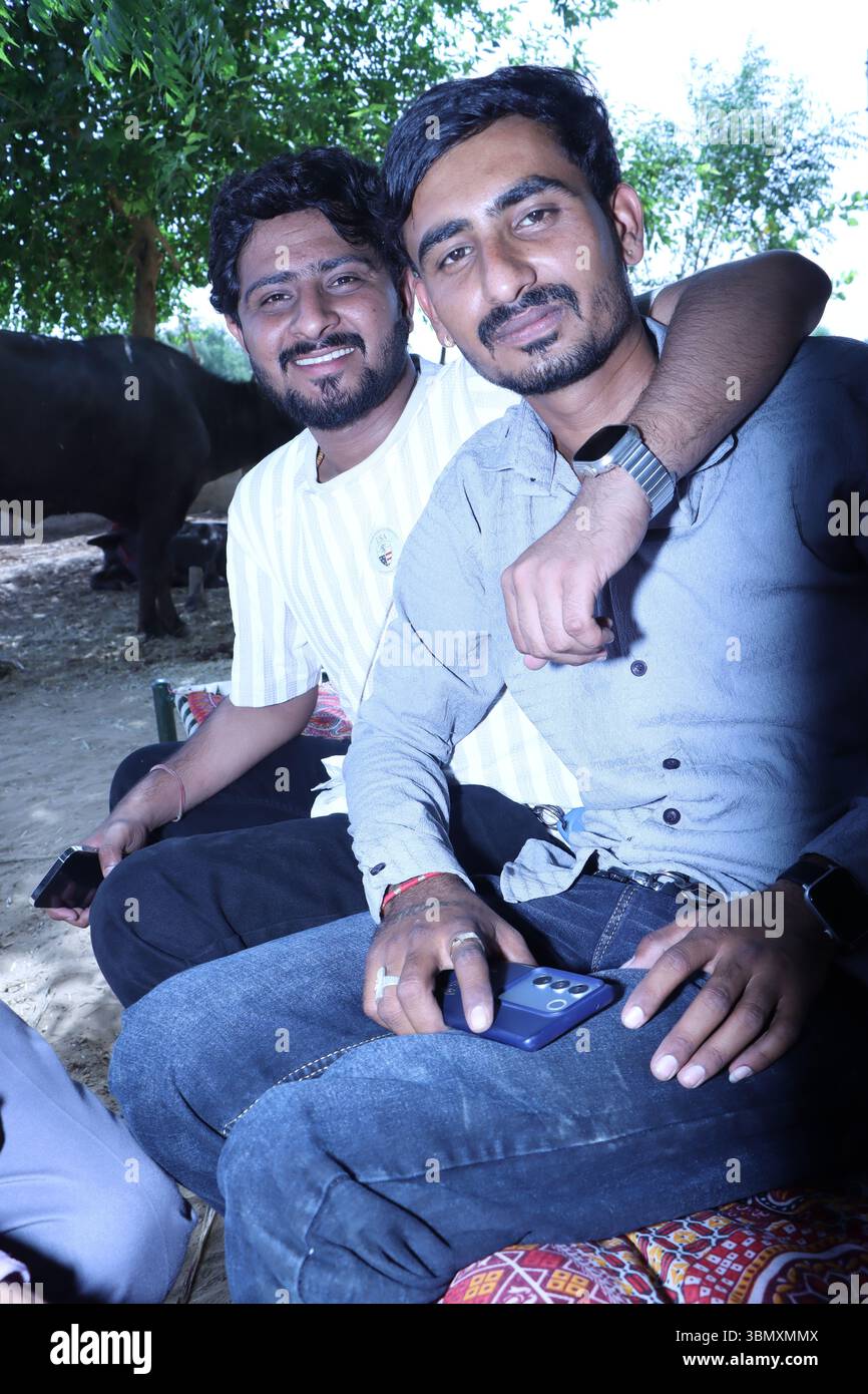 Zwei junge Indianer sitzen draußen und lächeln für die Kamera Stockfoto