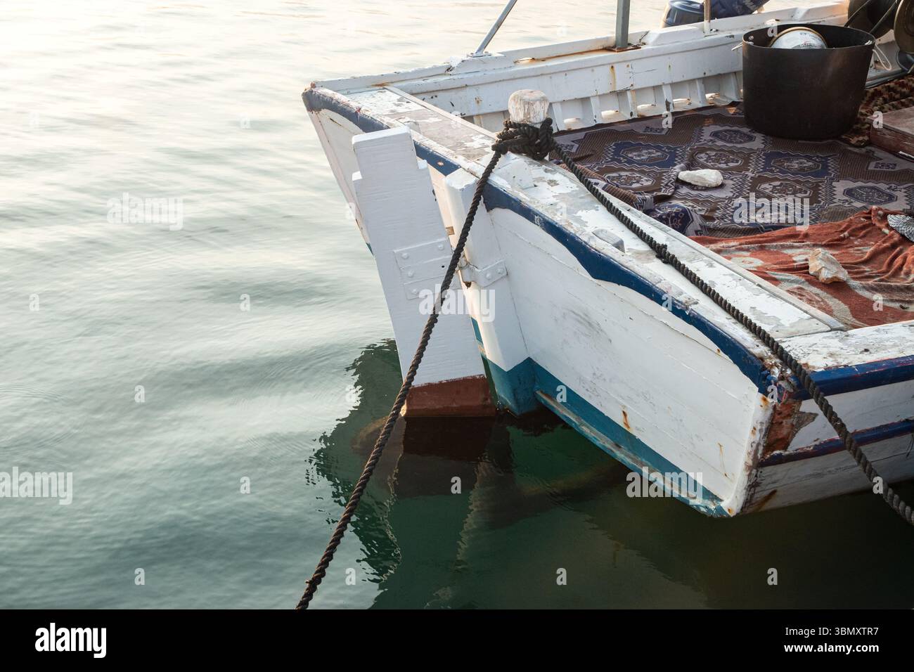 Nahaufnahme eines verwitterten, alten Fischerbootes mit blauen Anlegeseilen Stockfoto