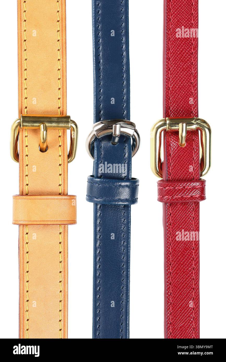 Es handelt sich um drei Ledergürtel und Schnallen, die auf weiß isoliert sind. Stockfoto