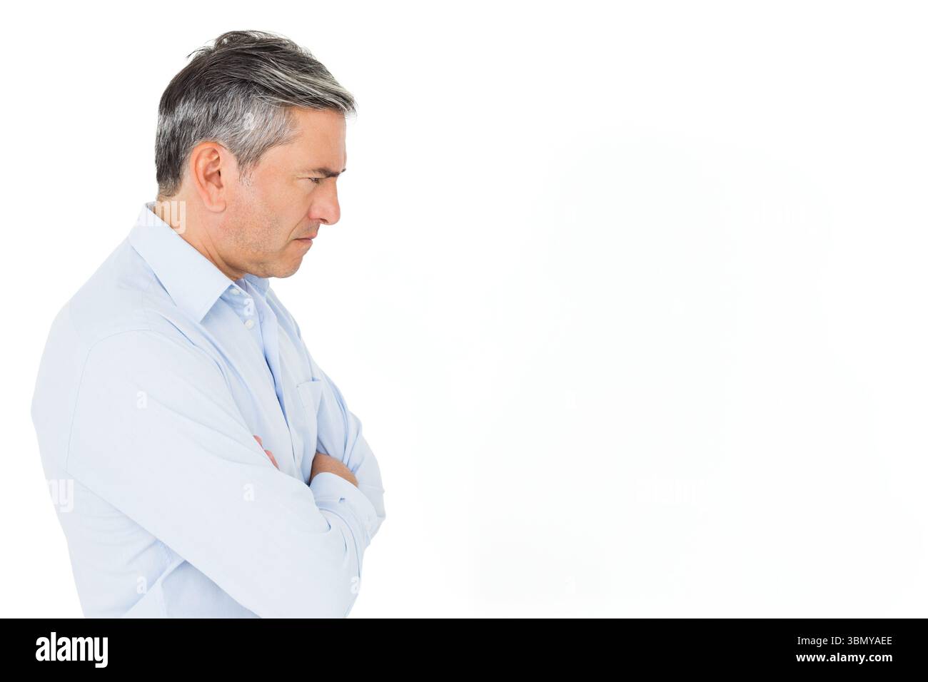 Senior-Mann mit hellblauem Hemd, faltet Arme und blickt direkt im Studio, Kopierraum Stockfoto