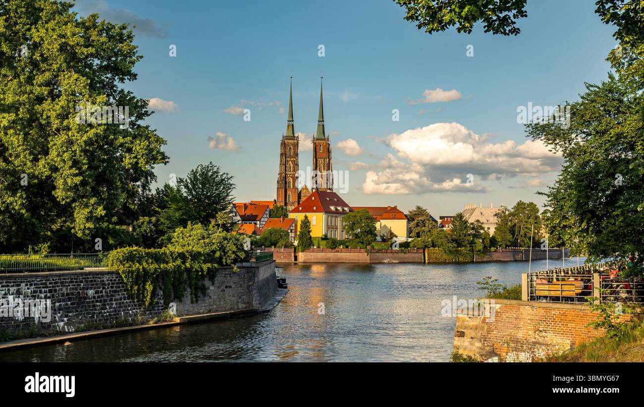 Ein lebendiges Bild einer historischen Stiftskirche vom Heiligen Kreuz, St. Bartholomäus, in der Nähe einer ruhigen oder unter blauem Himmel, Breslau, Polen Stockfoto