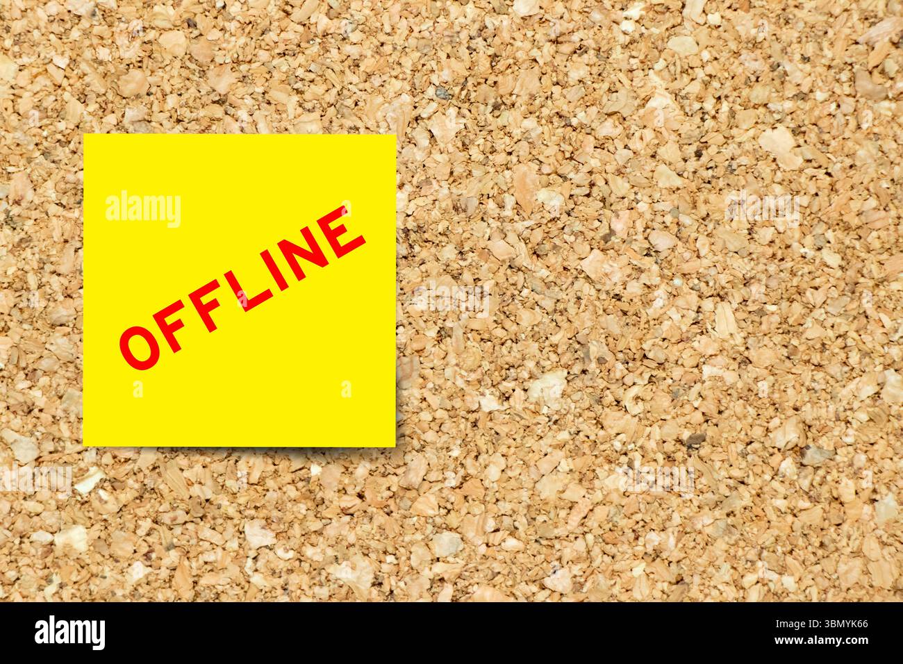 Gelbes Notizpapier mit Wort „offline“ auf Korkbrett-Hintergrund mit Kopierraum Stockfoto