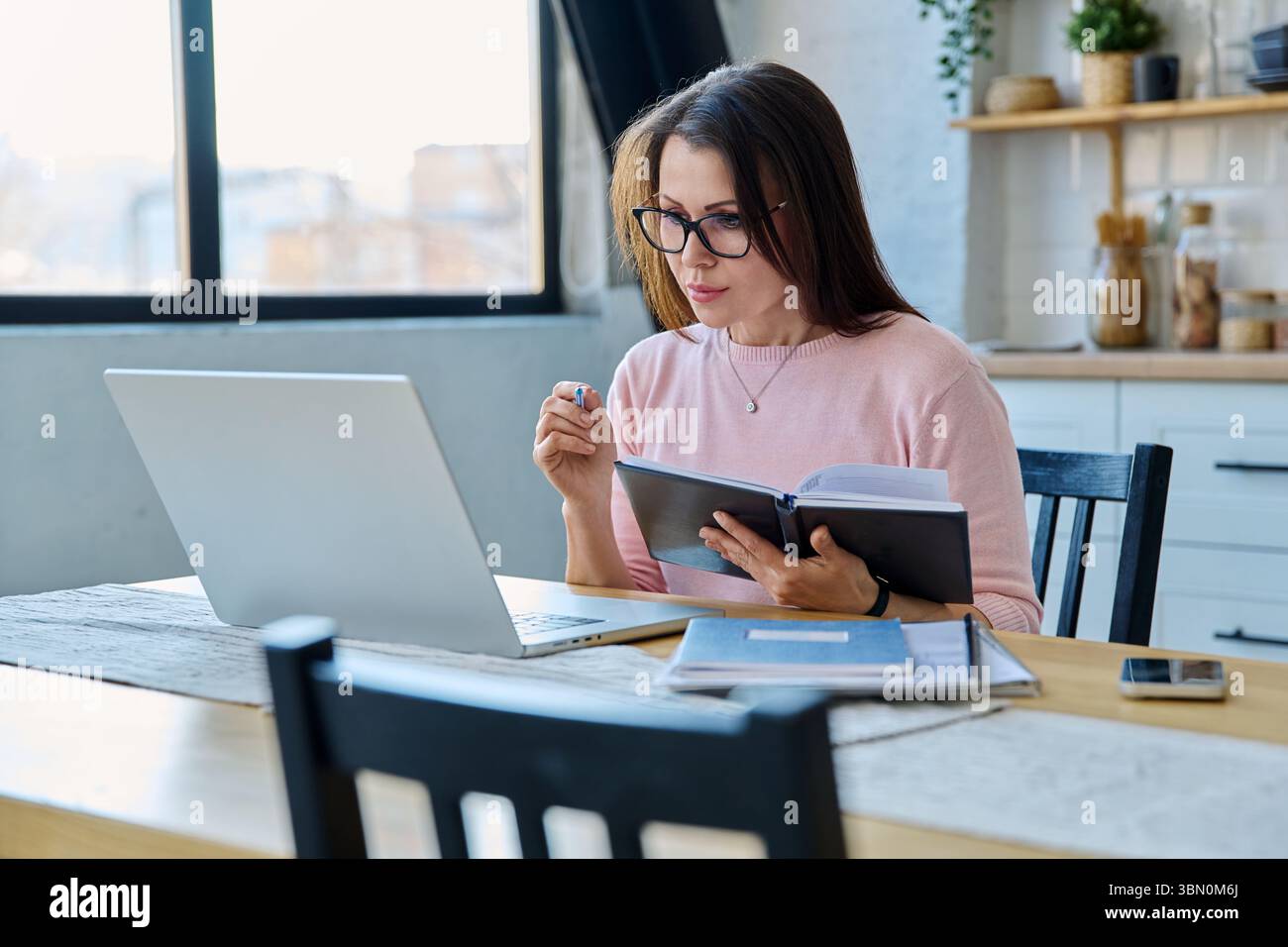 Ernsthafte Frau mittleren Alters, die im Home Office am Computer-Laptop arbeitet Stockfoto