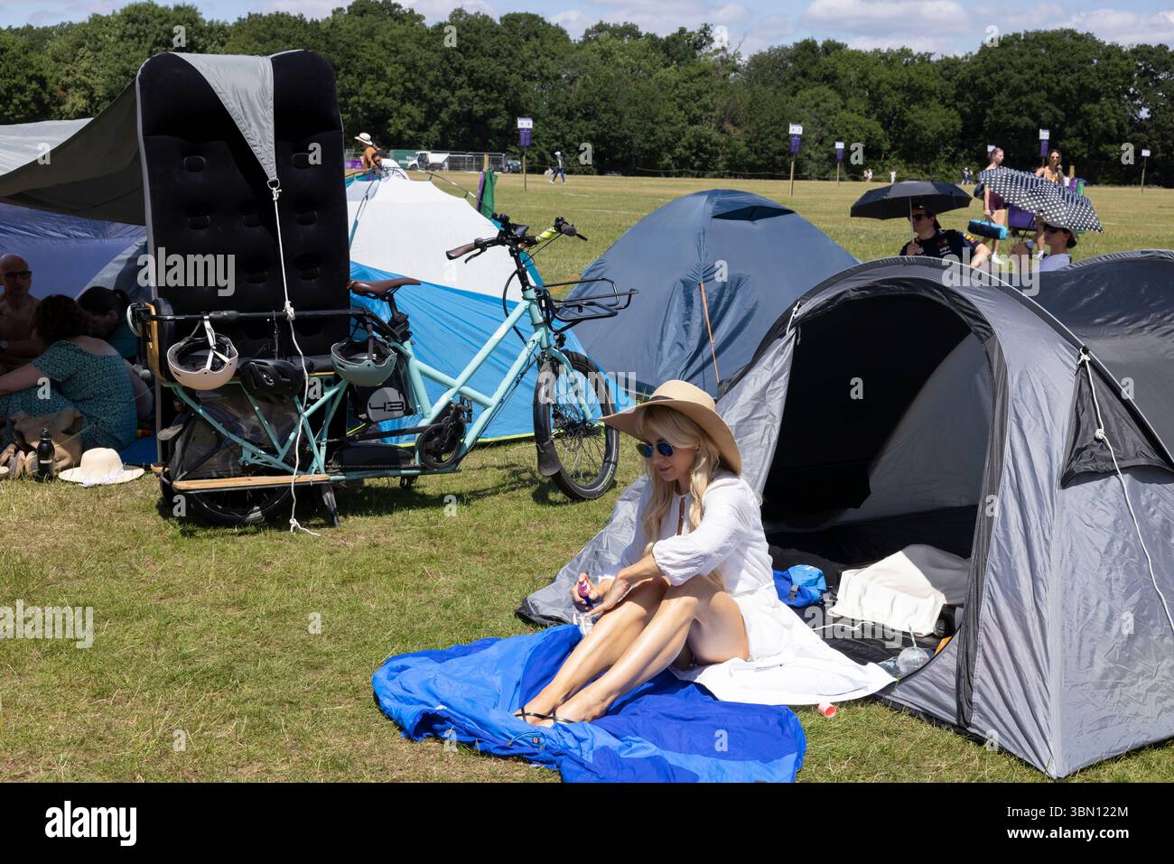 Wimbledon-Fans stellen Zelte an einem heißen Sommertag vor Beginn der Wimbledon Tennis Championships rund um die Uhr in der Warteschlange auf Stockfoto
