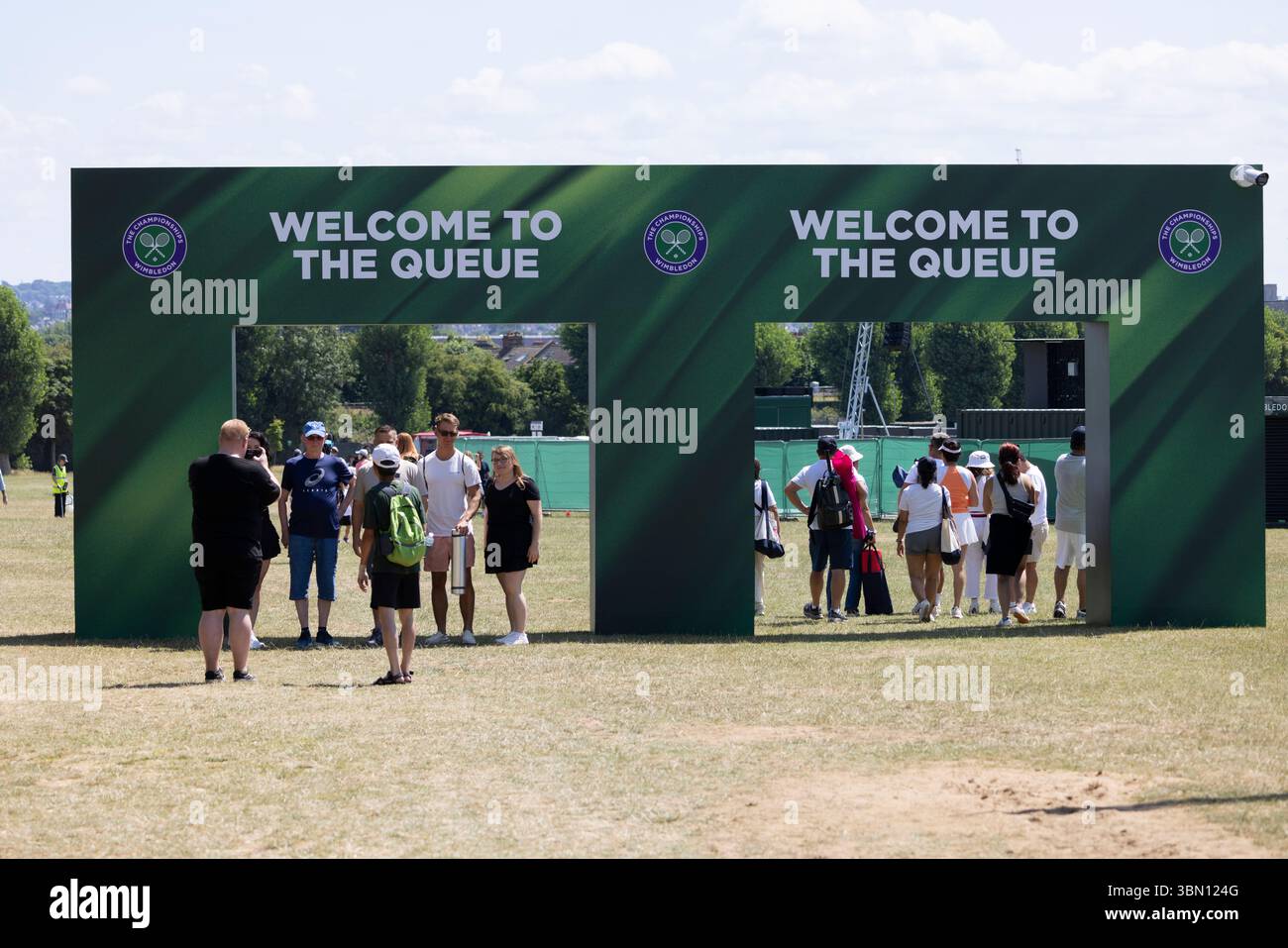 Wimbledon-Fans stellen Zelte an einem heißen Sommertag vor Beginn der Wimbledon Tennis Championships rund um die Uhr in der Warteschlange auf Stockfoto
