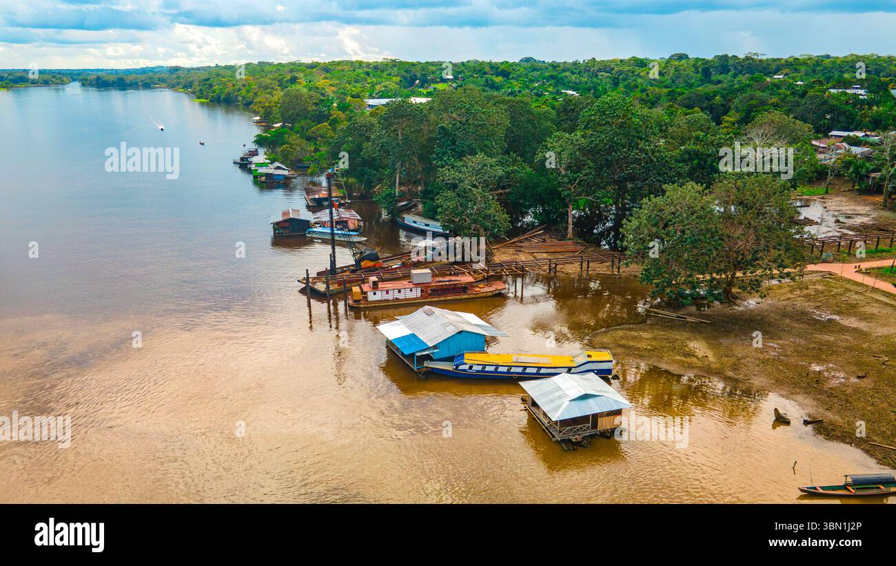 Aus der Vogelperspektive auf den Amazonasfluss in Leticia, Kolumbien, mit Booten und üppigem tropischem Dschungel, der Biodiversität und natürliche Schönheit hervorhebt. Stockfoto