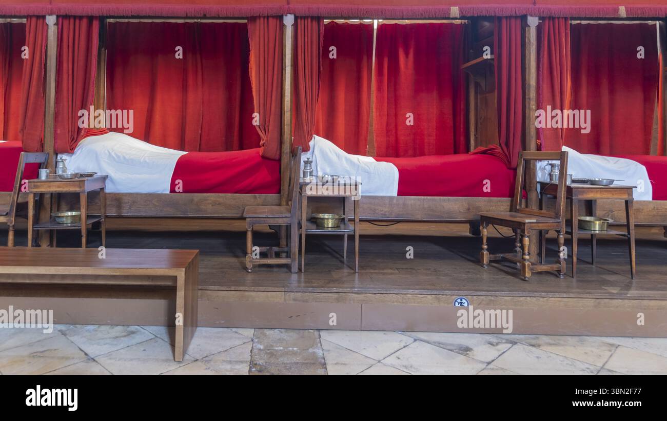 Beaune, Frankreich - 29. April 2024: Innenraum des Hauptzimmers mit roten Betten im Hospices de Beaune oder Hotel-Dieu de Beaune, einer ehemaligen karitativen Almshouse in an Stockfoto