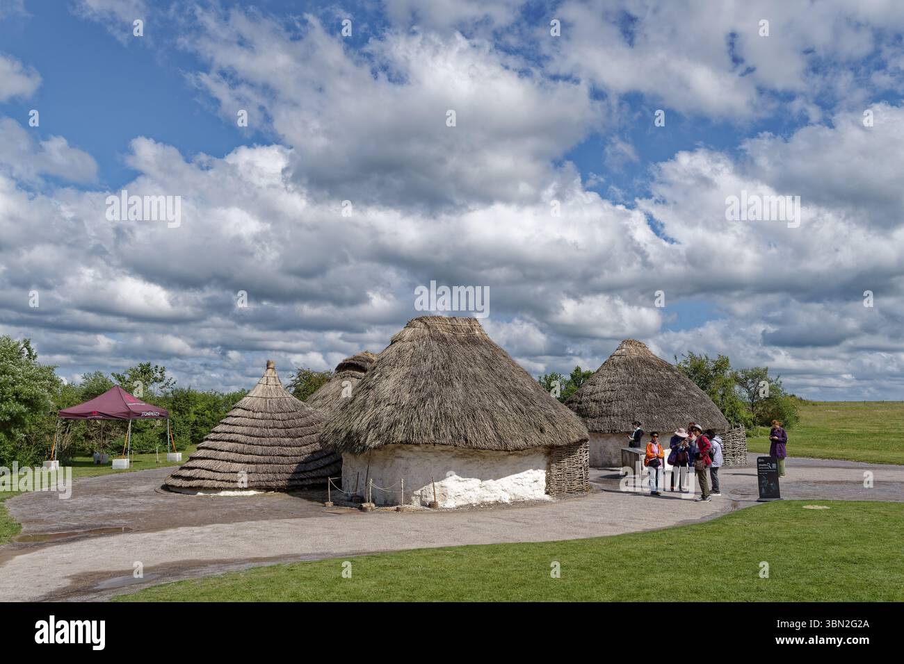 Touristen besuchen die Nachbauten neolithischer Häuser im Besucherzentrum Stonehenge. Amesbury, Wiltshire, Südengland, Großbritannien Stockfoto