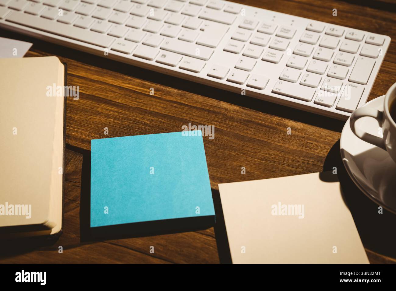 Tastatur und Kaffee auf dem Tisch mit Papieren Stockfoto