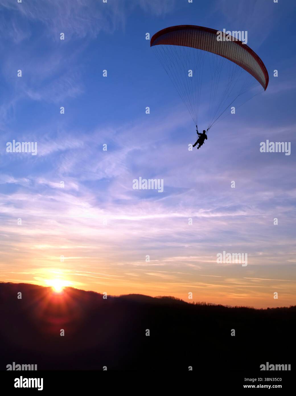Gleitschirmflieger in der Luft gegen den Abendhimmel Stockfoto