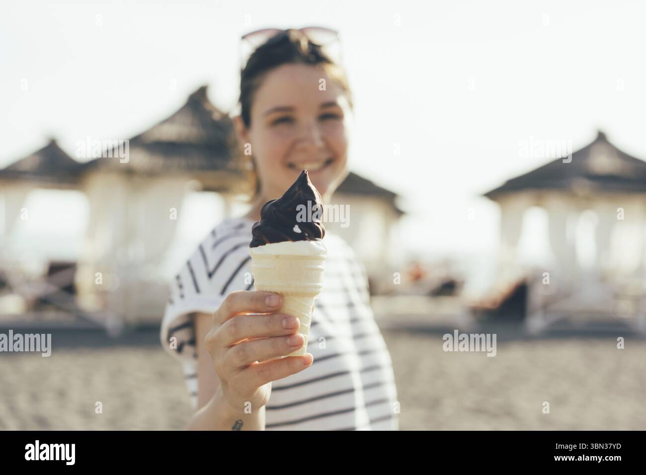Die junge Frau hält Eisbecher aus. Sommeressen Stockfoto