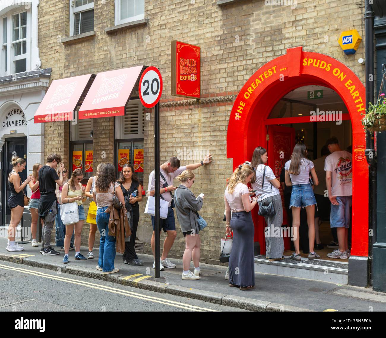 Warteschlange von Personen, die am Eingang warten Spud Bros Express Fast-Food Take away, Soho, London, England, Großbritannien Stockfoto