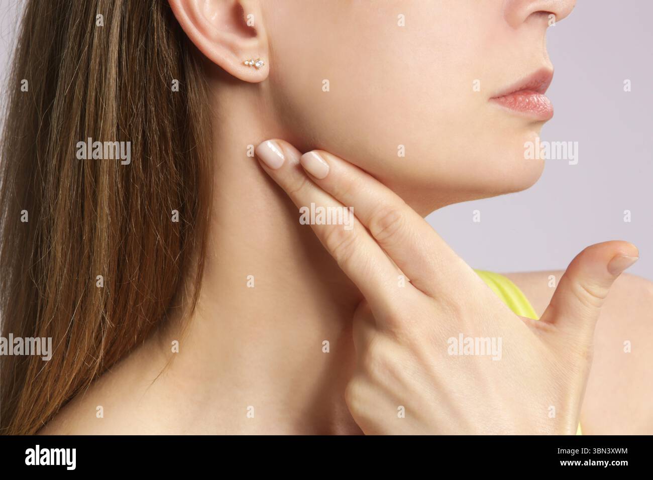 Eine kaukasische Frau, die ihren Hals berührt. Halsschmerzen, Erkältung, Grippe, Tonsillitis oder Schilddrüsenproblem Stockfoto