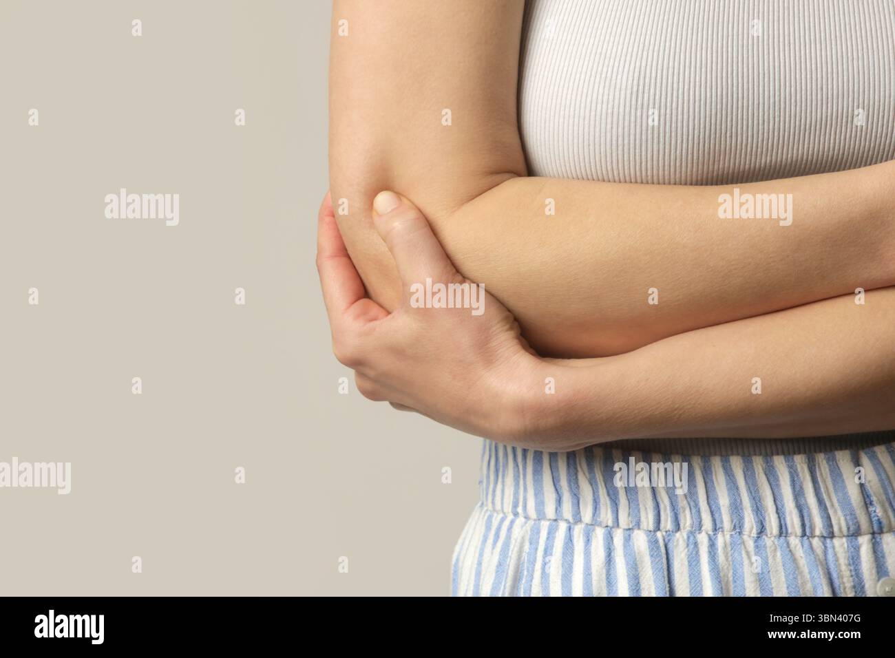 Akute Ellbogenschmerzen. Die Frau hält die Hand an ihrem schmerzhaften Ellbogen. Stockfoto