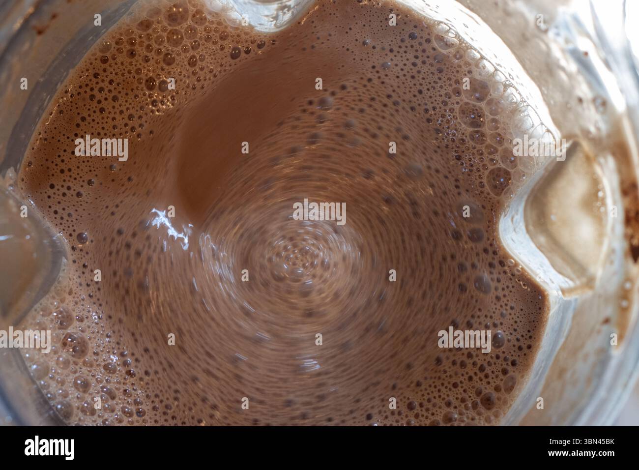 Wirbelnder Wirbel von sprudelndem Schokoladen-Käsekuchen-Teig Stockfoto