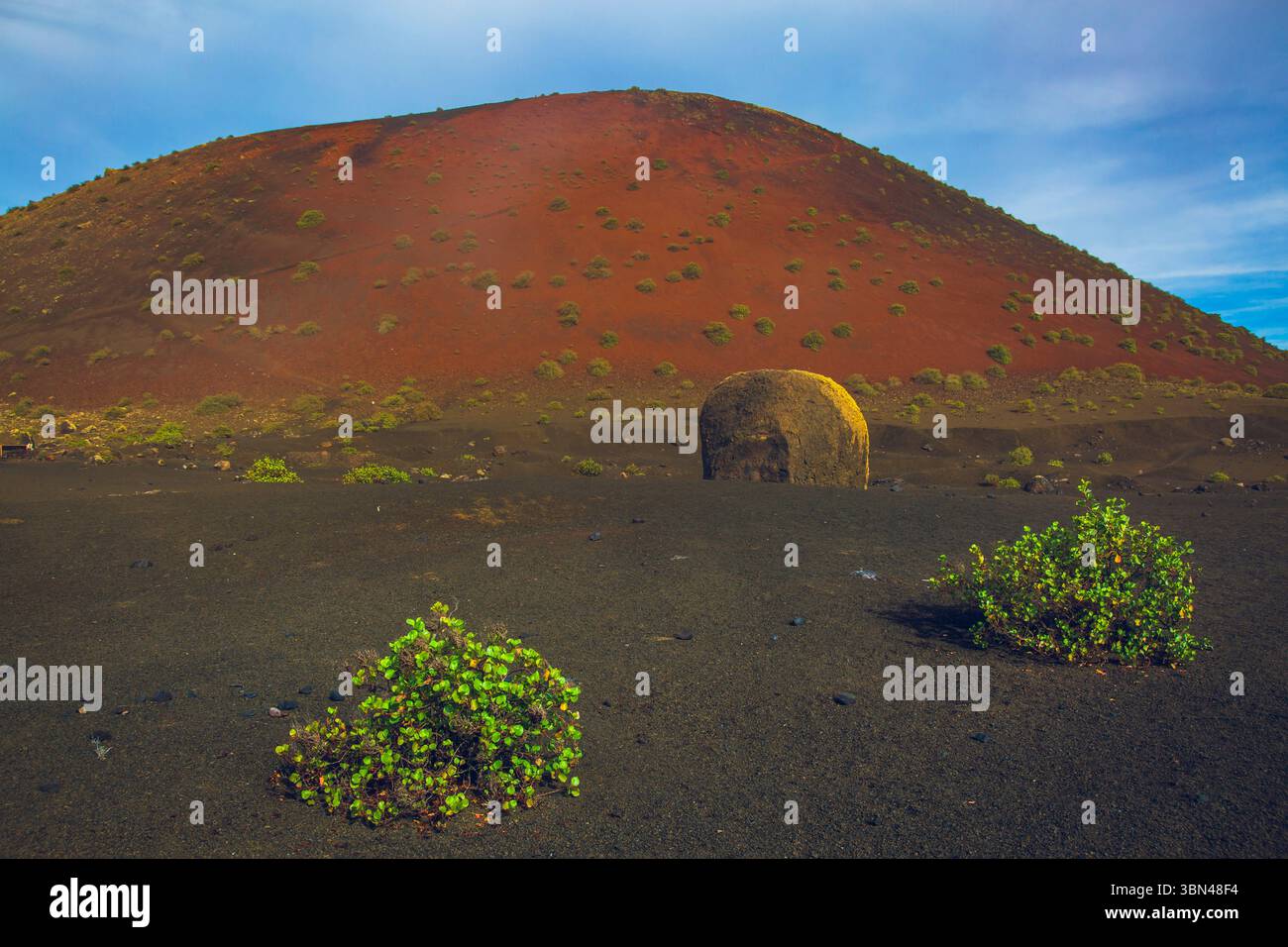Spanien, Kanarische Inseln, Lanzarote, Timanfaya Park. Caldera Colorada. Im Vordergrund die Vulkanbombe. Stockfoto