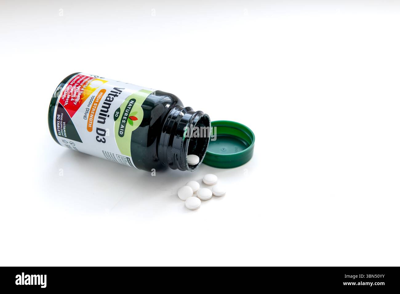 London. UK- 06.27.2025. Eine offene Flasche Vitamin D3 und Tabletten isoliert auf weiß. Stockfoto