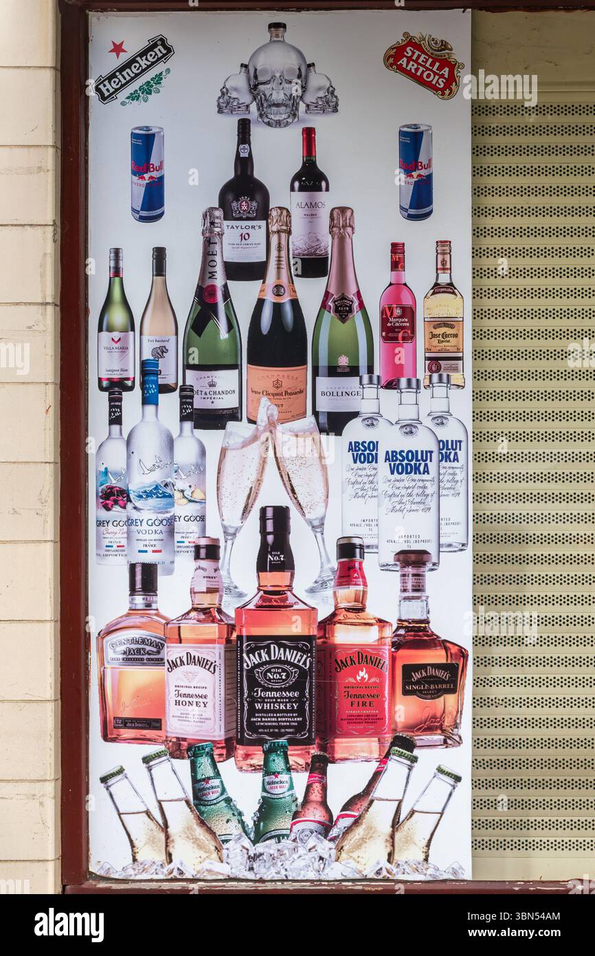 Poster für Getränke und Alkohol, einschließlich Bier, Wein und Spirituosen, im Fenster eines Spirituosengeschäfts oder -Ladens in England, Großbritannien Stockfoto