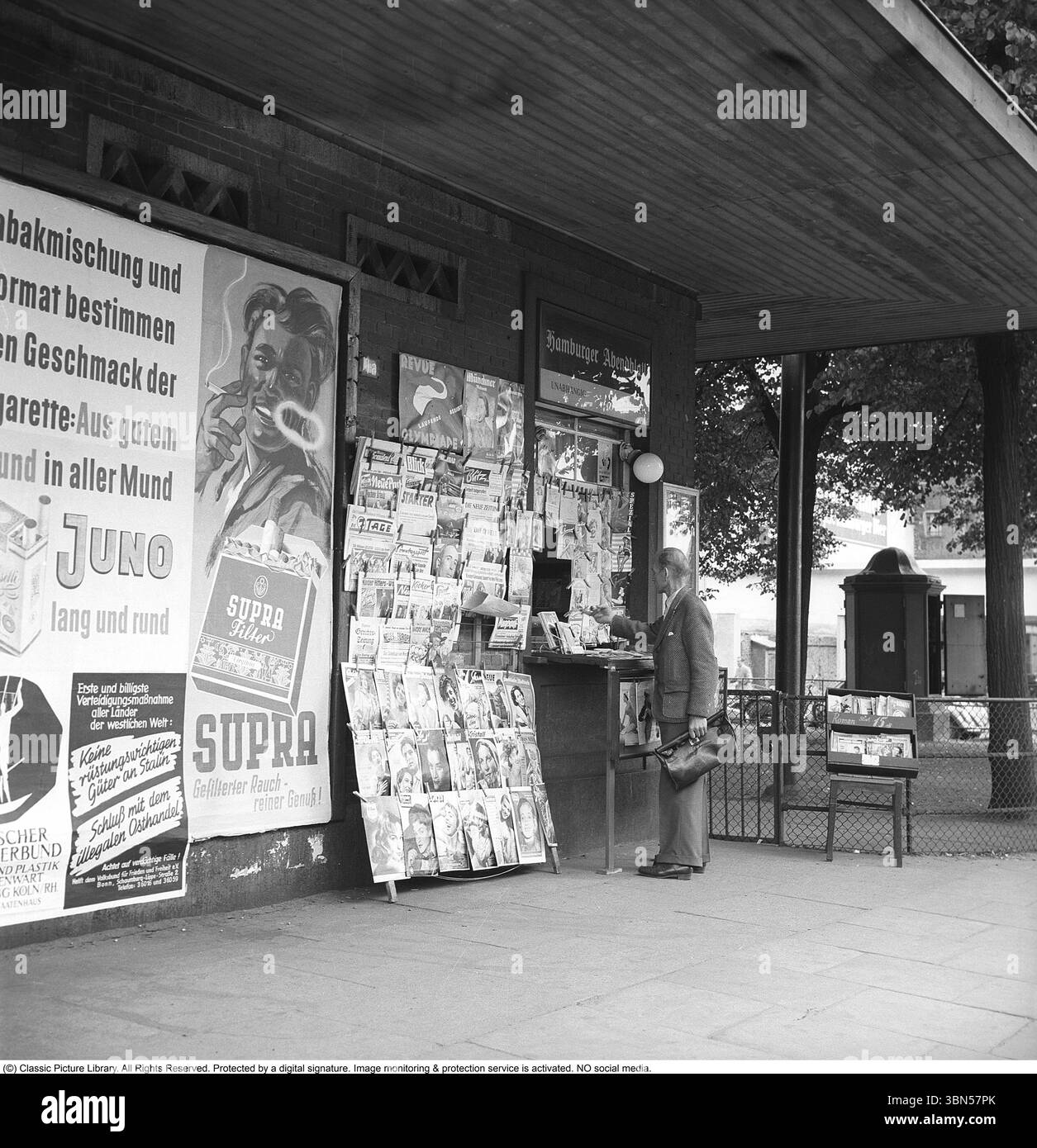 Der Zeitungs- und Zeitschriftenladen 1952. Ein Mann wird in einem Geschäft gesehen, das Zeitschriften und Zeitungen verkauft. Davor eine Reihe von Zeitschriften, die zu dieser Zeit im Handel waren. Eine Werbung für Supra-Zigaretten mit dem Tag gefilterter Rauch, sauberer Rauch... Hamburg 15. juli 1952. Conard Ref. DV22 Stockfoto