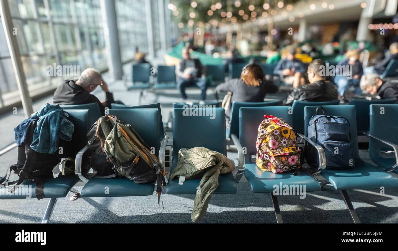Fünf Handgepäckkoffer, die in einer Abfluglounge am Flughafen auf fünf Sitzplätzen untergebracht sind. Stockfoto Fünf Handgepäckkoffer, die in einer Abfluglounge am Flughafen auf fünf Sitzplätzen untergebracht sind. Stockfoto