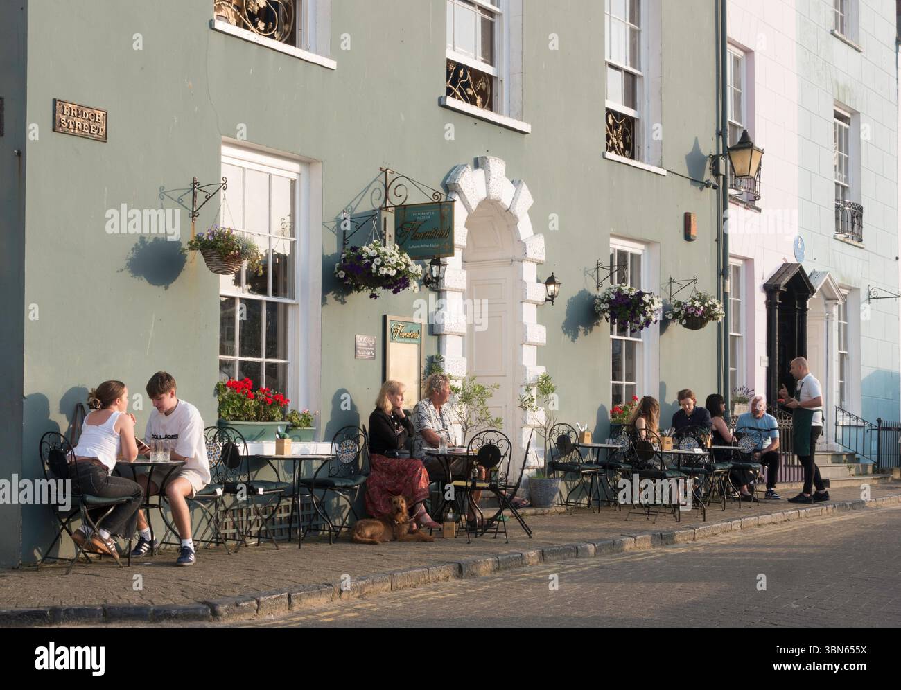 Leute, die vor dem italienischen Restaurant von Florentino in Tenby, Pembrokeshire, Wales, Großbritannien, sitzen Stockfoto