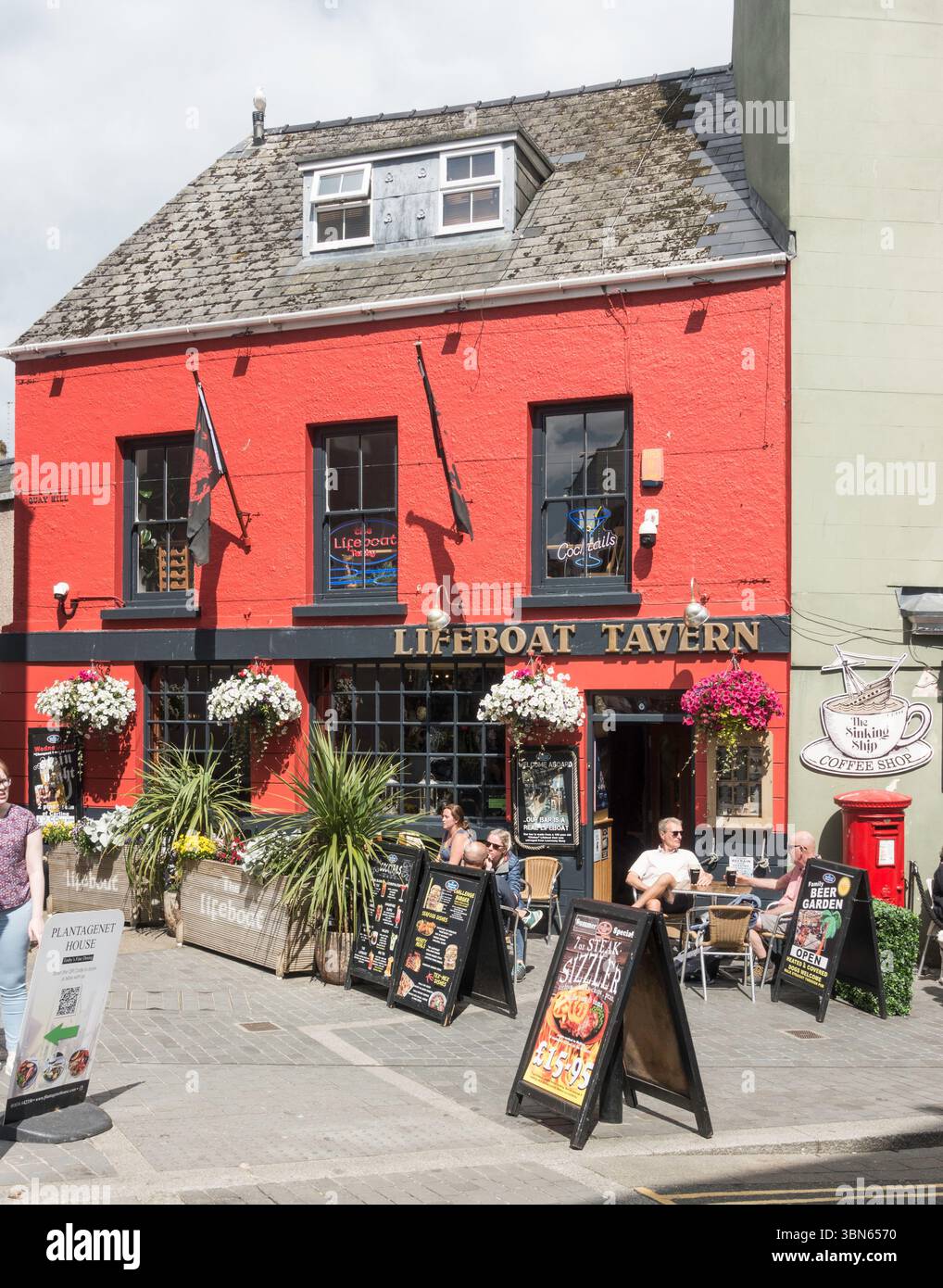 Leute, die vor der Lifeboat Tavern in Tenby, Pembrokeshire, Wales, Großbritannien sitzen Stockfoto