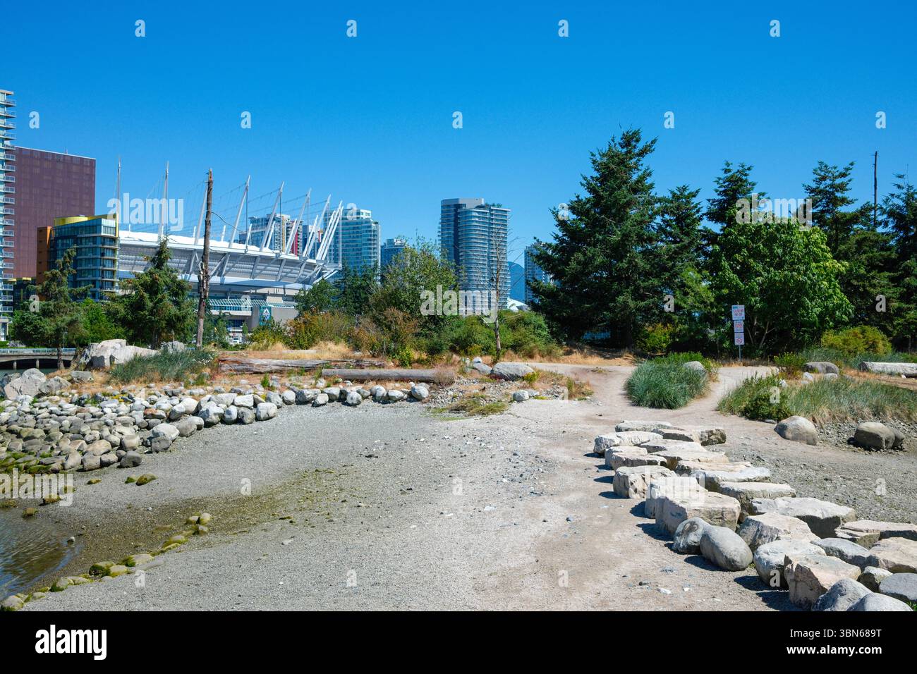 Pfad zur Habitat Island entlang des False Creek mit BC Place Stadium und dem Parq Casino gegenüber, Vancouver, BC. Stockfoto