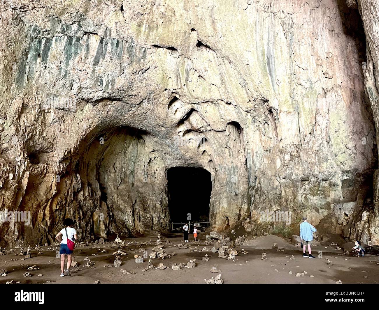 Menschen erkunden die riesige Kuppelkammer der Devetaschka-Höhle, eine spektakuläre natürliche Attraktion im ländlichen Bulgarien, Osteuropa - Smartphone-aufgenommenes Stockfoto