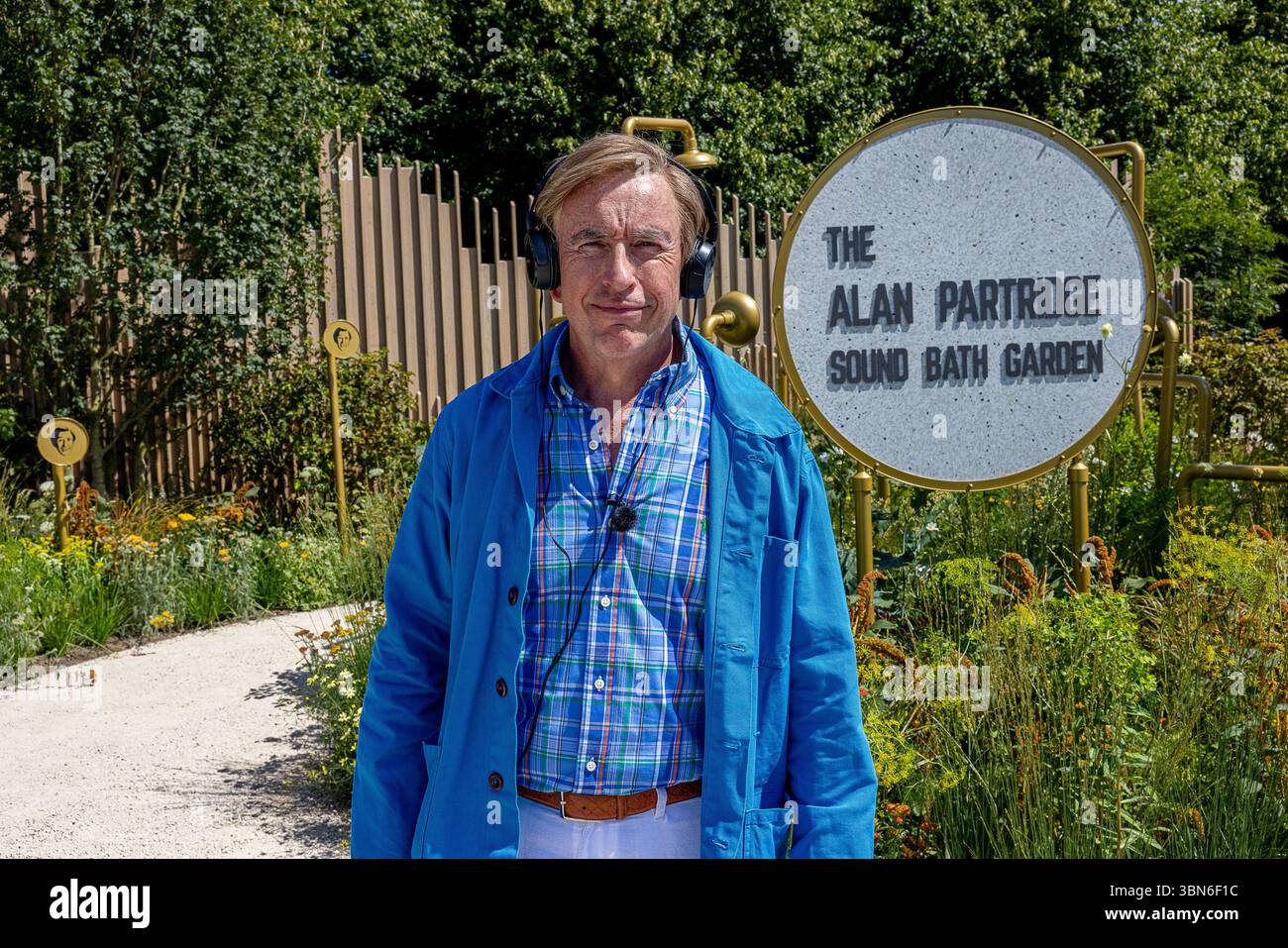 Steve Coogan wurde beim Hampton Court Palace Garden Festival als Alan Partridge als Schauspieler gesehen. Er trat im Alan Partridge Sound Bath Garden auf, entworfen von Joe und Laura Carey, während er bei 32 °C mit einem Handventilator und einem Regenschirm kühl blieb. Quelle: David Betteridge/Alamy Live News Stockfoto