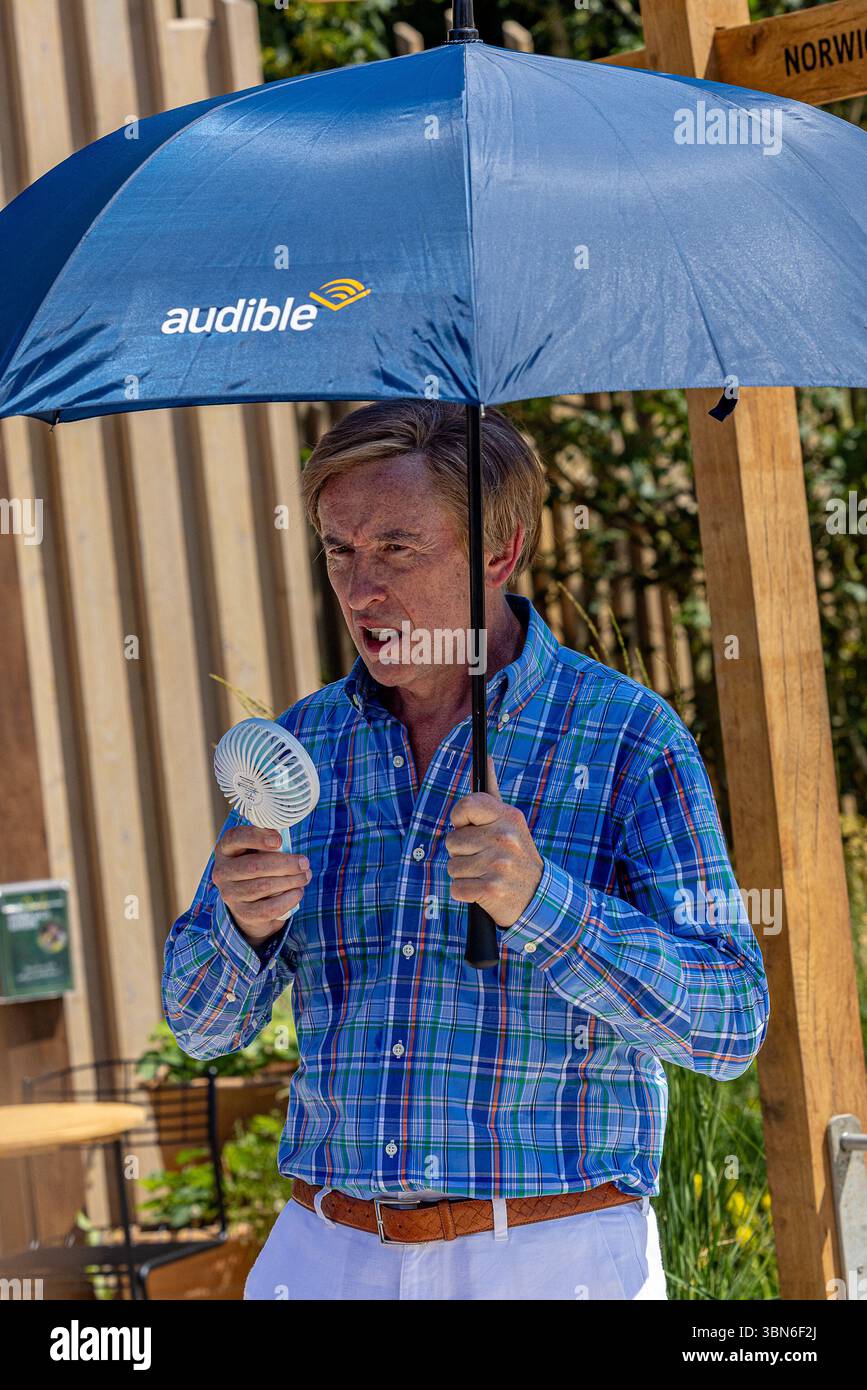 Steve Coogan wurde beim Hampton Court Palace Garden Festival als Alan Partridge als Schauspieler gesehen. Er trat im Alan Partridge Sound Bath Garden auf, entworfen von Joe und Laura Carey, während er bei 32 °C mit einem Handventilator und einem Regenschirm kühl blieb. Quelle: David Betteridge/Alamy Live News Stockfoto