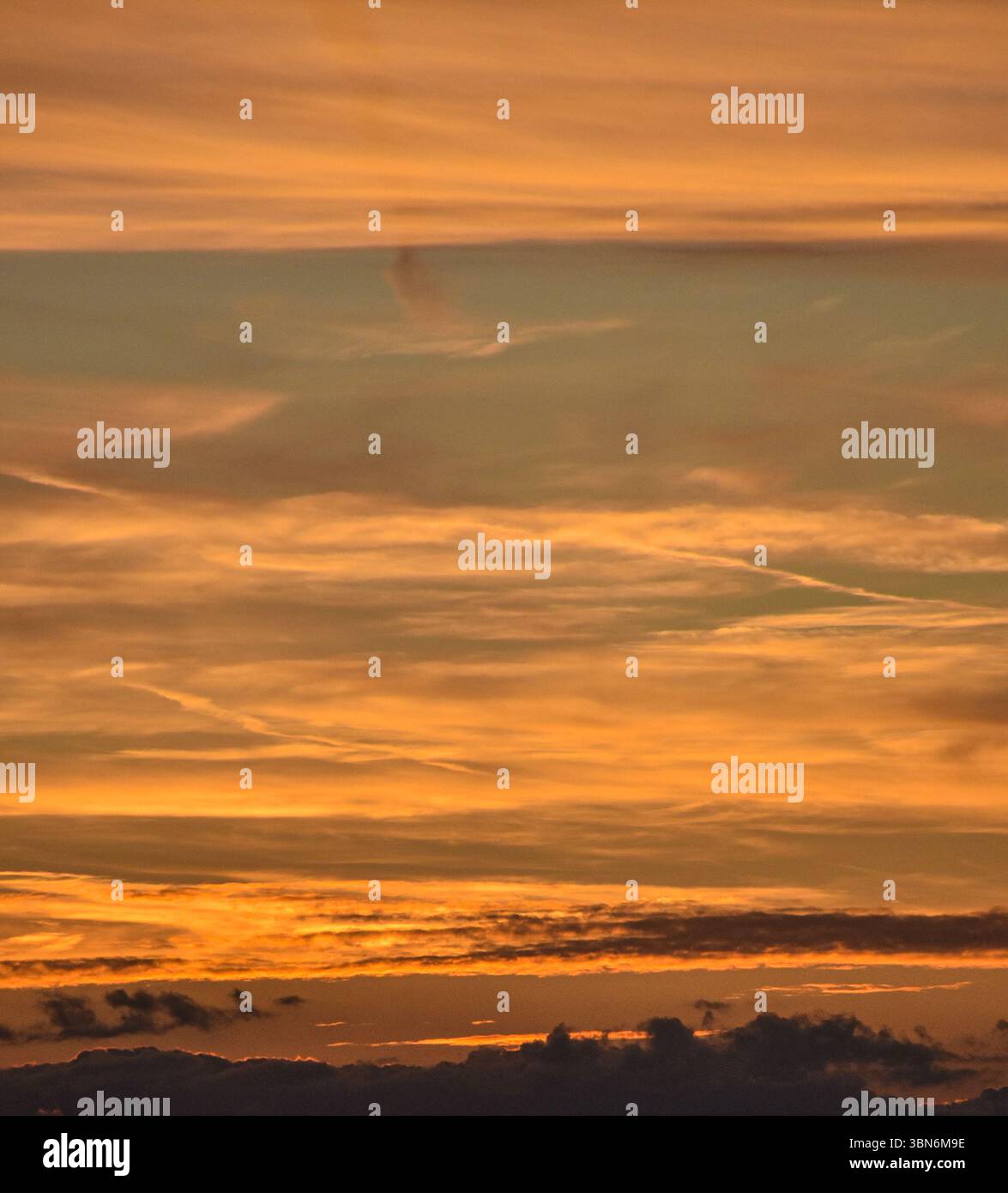Ein spektakulärer Sonnenuntergang mit einem brennenden Himmel in orange Tönen schafft eine warme und friedliche Atmosphäre am Ende des Tages. Stockfoto