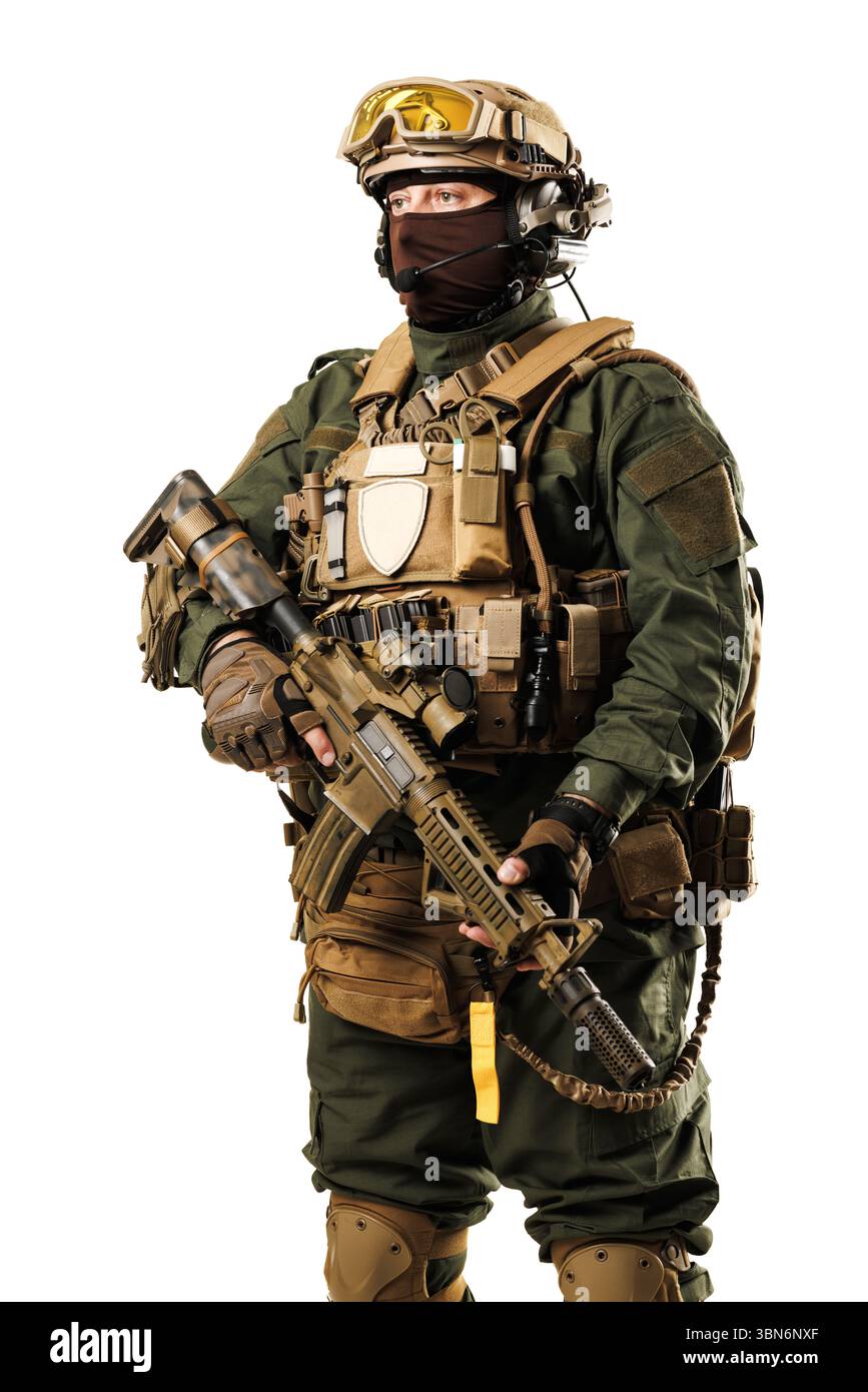 Ein Soldat in taktischer Ausrüstung, einschließlich Helm, Tarnkleidung und Gewehr, steht selbstbewusst einsatzbereit Stockfoto