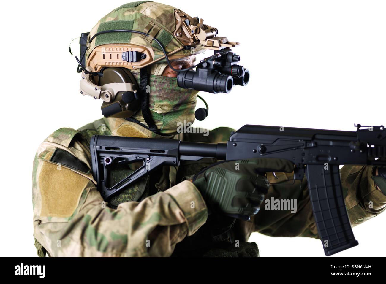 Taktischer Soldat, getarnt, mit einem Gewehr und fortschrittlicher Militärausrüstung, einschließlich Helm mit Nachtsichtbrille, Pose i Stockfoto
