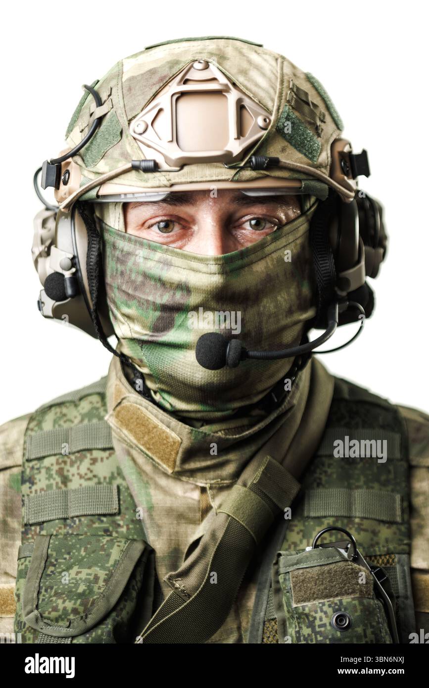 Das Bild zeigt einen Soldaten in strategischer Kleidung, ausgestattet mit einem Headset und taktischer Ausrüstung. Der Ausdruck steht für Engagement und Bereitschaft, mit t Stockfoto