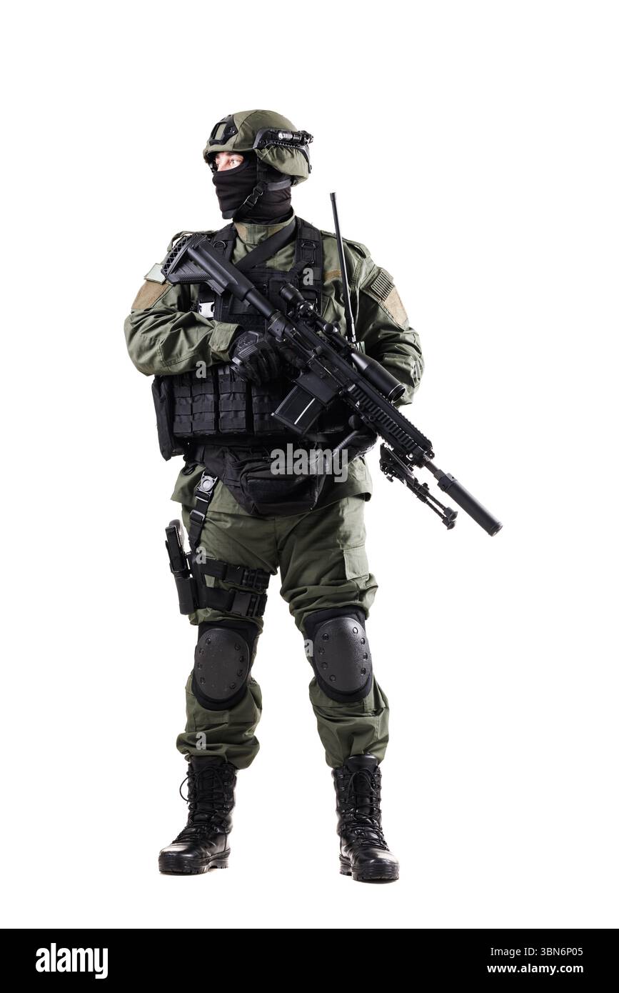 Bewaffneter Soldat mit taktischer Ausrüstung und ausgestattet mit Schusswaffen, Schutzpolstern und Kommunikationsausrüstung, die Bereitschaft und Professionalität zum Ausdruck bringen Stockfoto