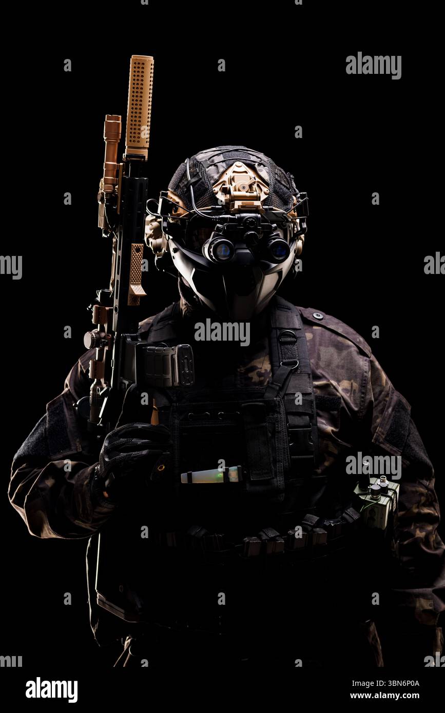 Eine Militärfigur in fortgeschrittener Kampfausrüstung, ausgestattet mit einem Gewehr und einer Nachtsichtbrille, die Sicherheit, taktisches Know-how und Anonym betont Stockfoto