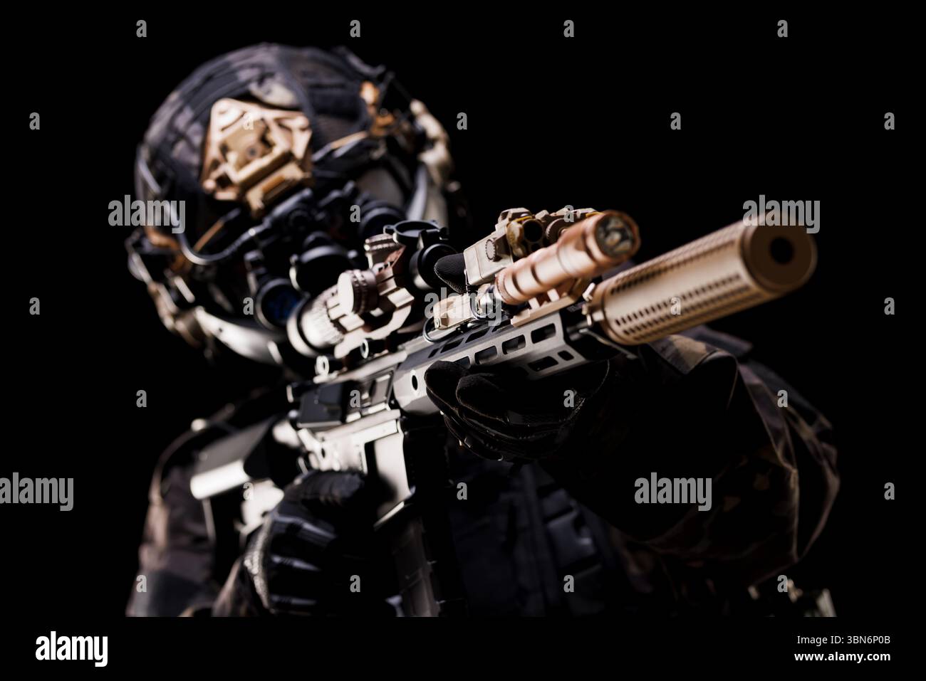 Ein Soldat der Spezialkräfte mit fortschrittlicher taktischer Ausrüstung, der ein Gewehr bei dunkler Beleuchtung anvisiert. Das Bild hebt Präzision, Technologie und Professionalität hervor, Stockfoto