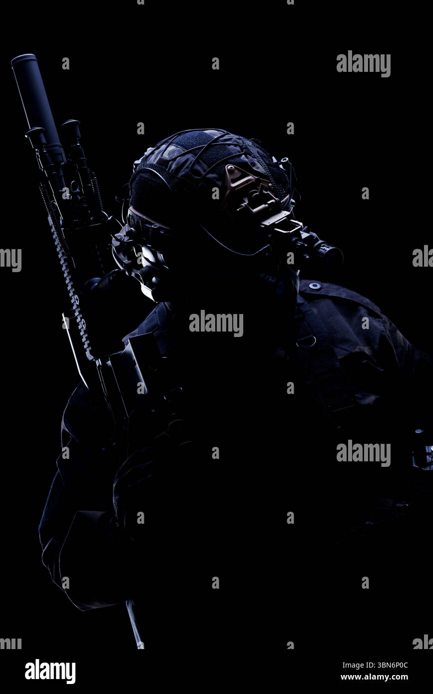 Militärpersonal bewaffnet und ausgestattet mit Nachtsicht und Ausrüstung, in dramatischer Silhouette. Stockfoto