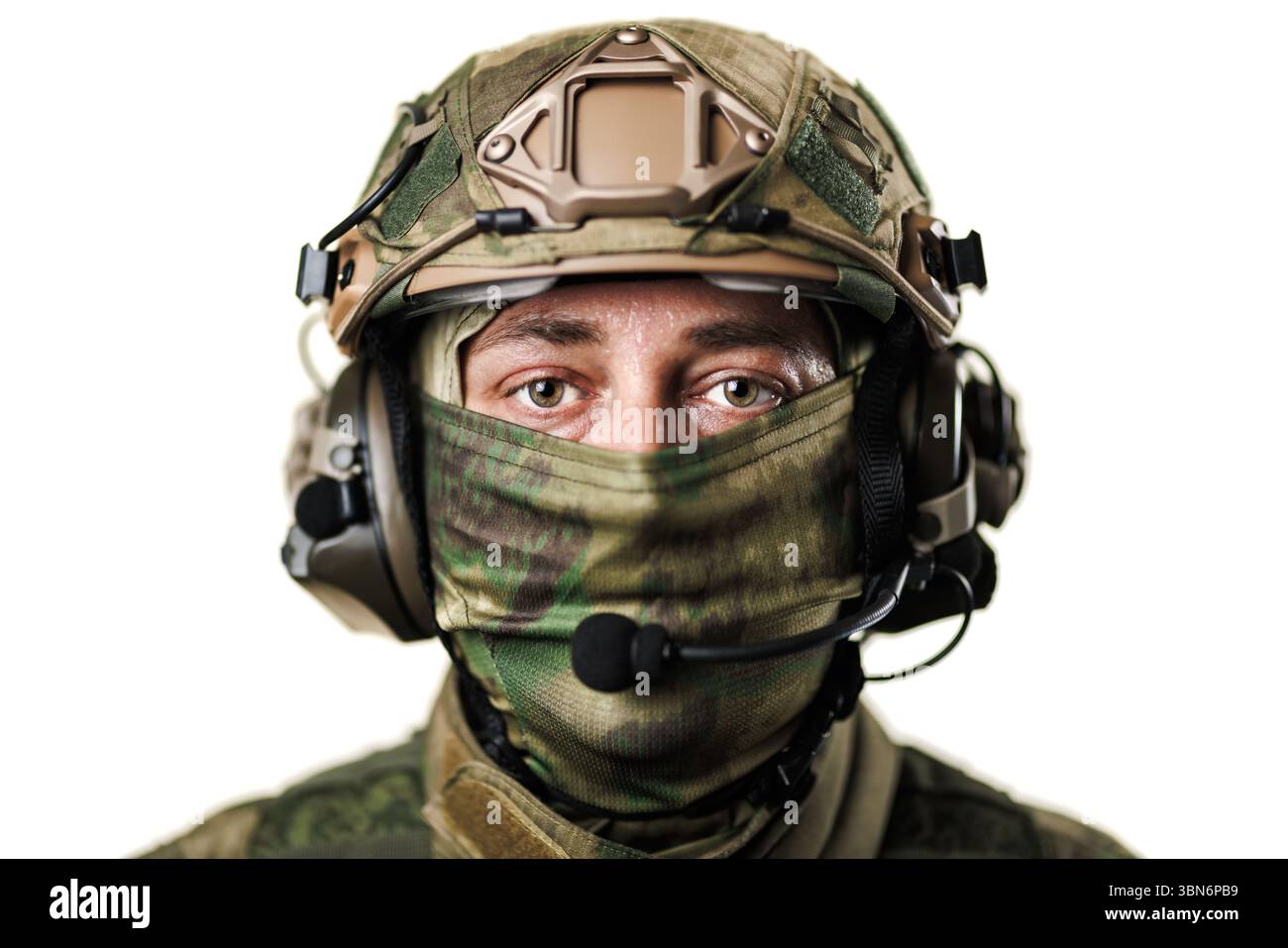Nahaufnahme eines Militärsoldaten mit taktischem Helm, Gesicht bedeckt mit Tarnstoff und Headset. Stockfoto