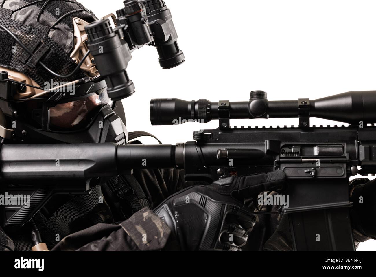 Ein Soldat in taktischer Ausrüstung, einschließlich Gewehr und Nachtsichtbrille, greift intensiv ein. Das Setting hebt Präzision, Bereitschaft und Militär hervor Stockfoto
