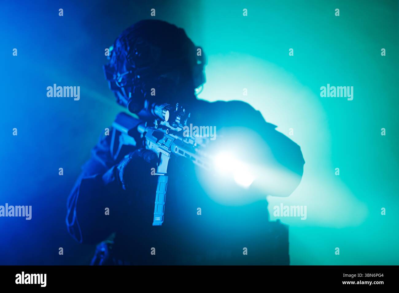 Ein Soldat in taktischer Ausrüstung zielt in dramatischer Beleuchtung mit Blau- und Grüntönen auf ein Gewehr, das eine intensive und actionorientierte Atmosphäre schafft. Stockfoto