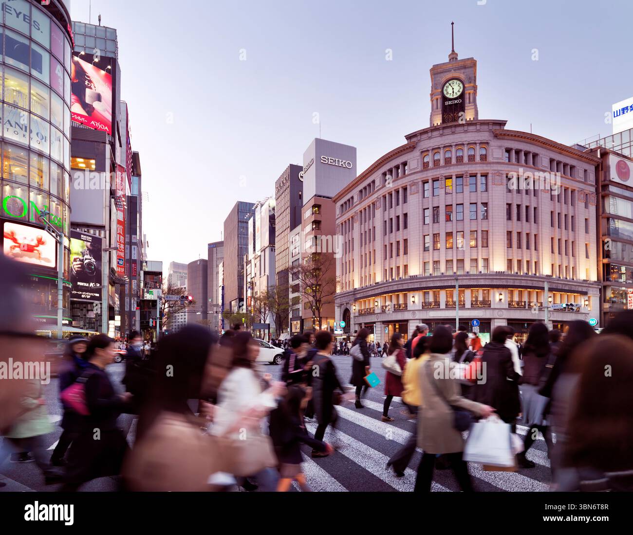 Menschen, die die Straße vor dem Gebäude des Kaufhauses Wako in Ginza, Tokio, Japan überqueren. Stockfoto