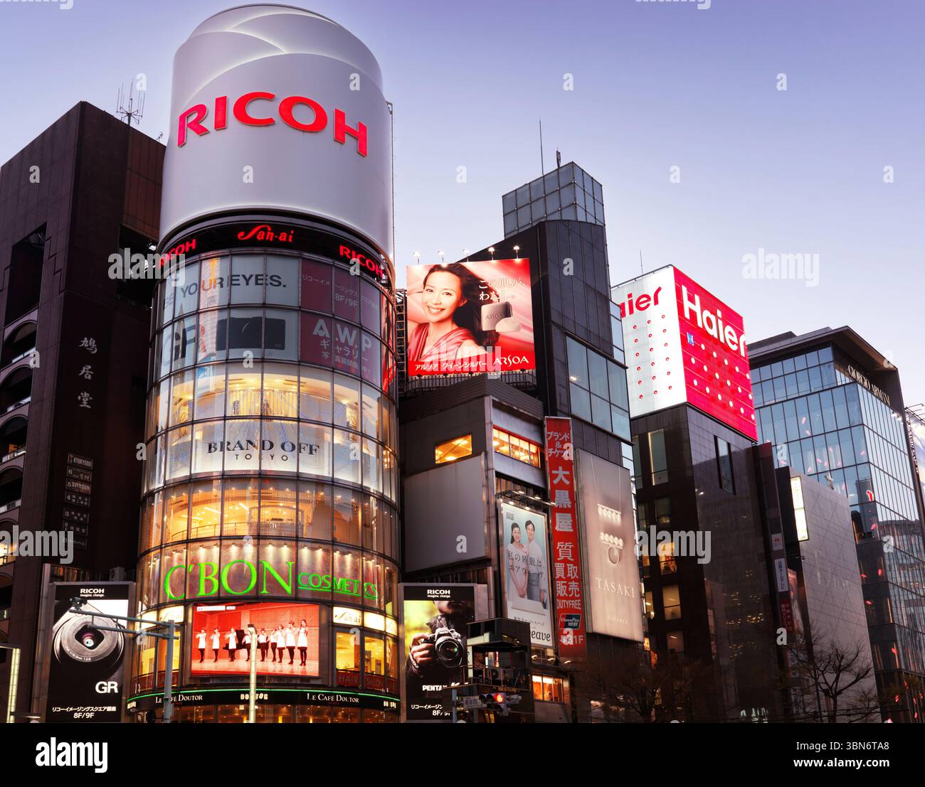 Ricoh-Gebäude und bunte Schilder bei Nacht in Ginza, Tokio, Japan. Stockfoto