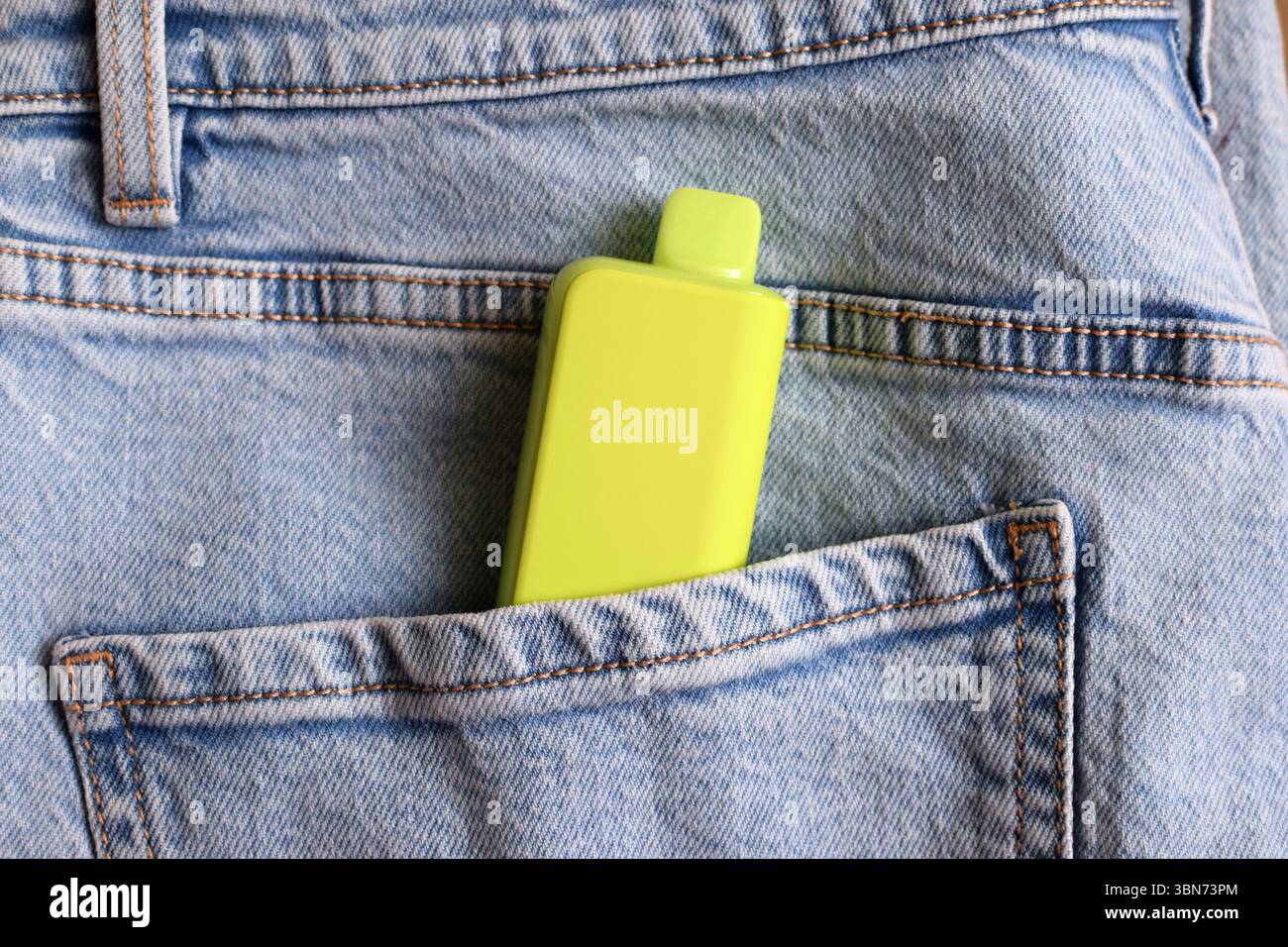 Eine mehrfarbige elektronische Zigarette in der Hosentasche der Jeans. Vape mit Nikotin. Stockfoto